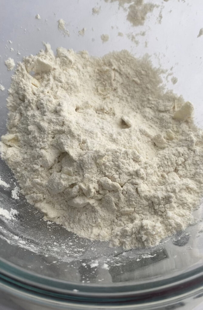 Butter partially worked into a bowl of flour.