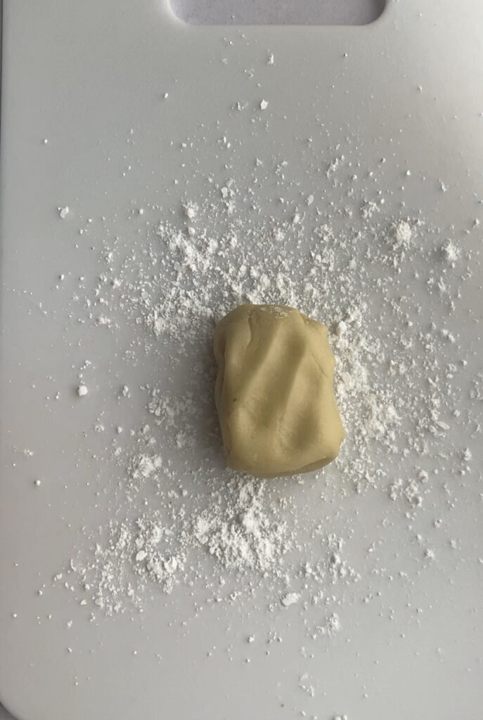 A block of almond paste on a cutting board.