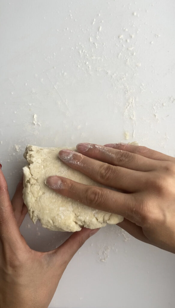 Folding the scone dough over the jam and almond paste.