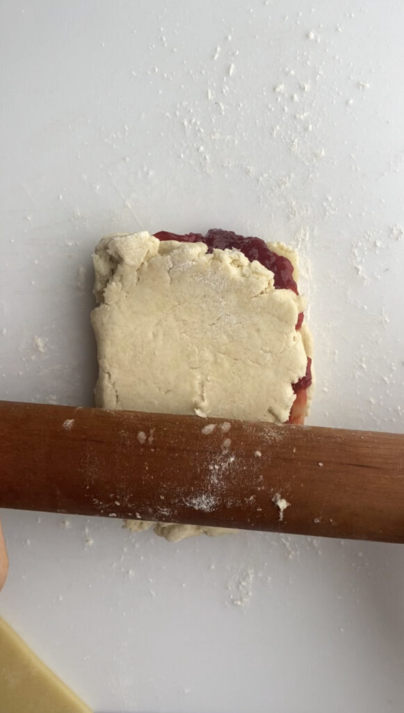 Rolling out the folded over scone dough.