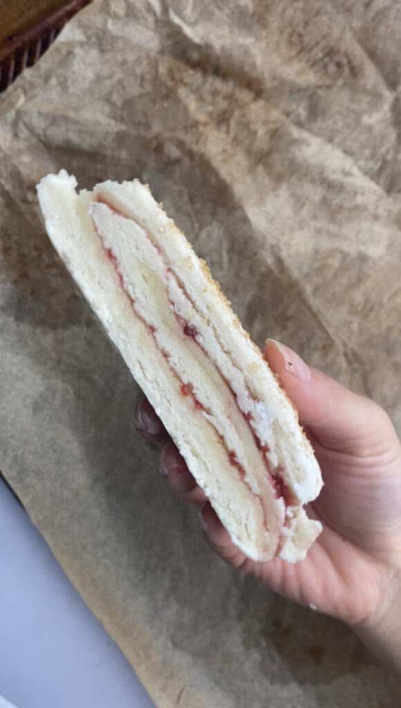 Showing the inside of an unbaked scone with layers of jam and almond paste.
