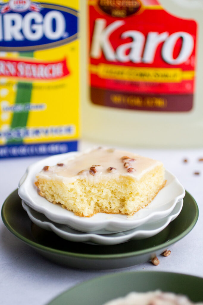A slice of Texas sheet cake on a white plate with a bite taken out of it.