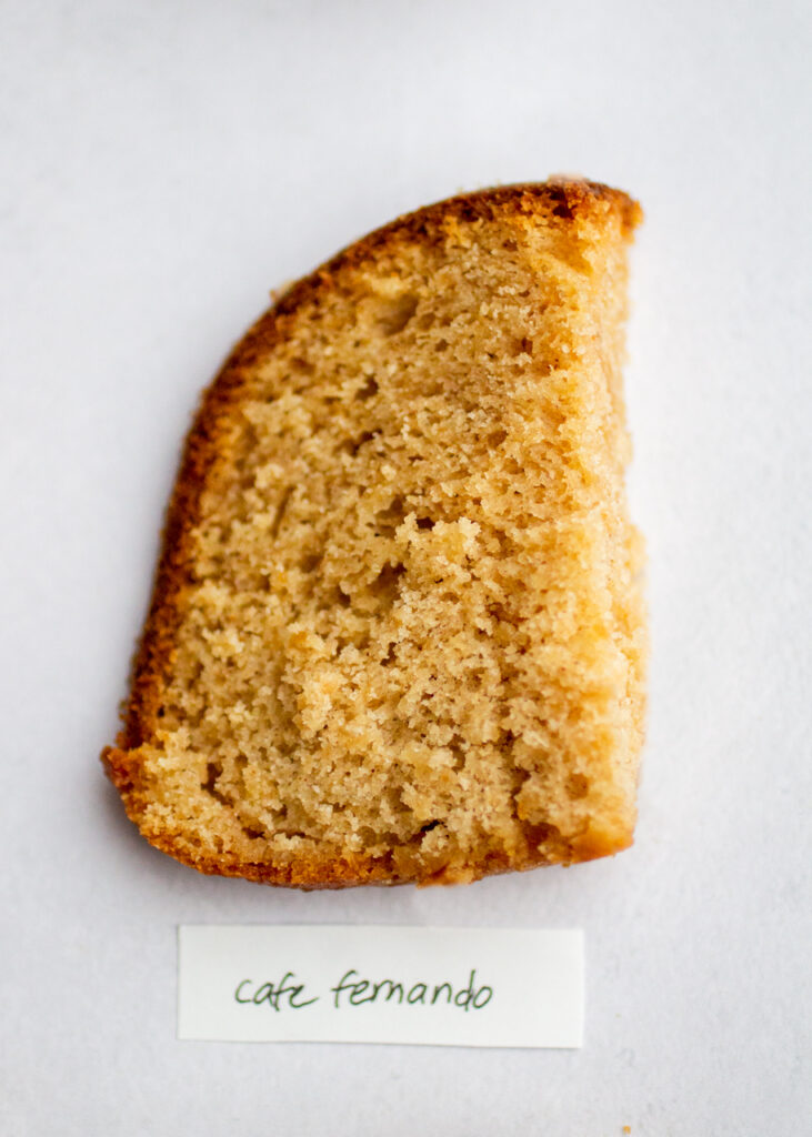 a slice of apple cake with the label \"cafe fernando\" on a gray background.