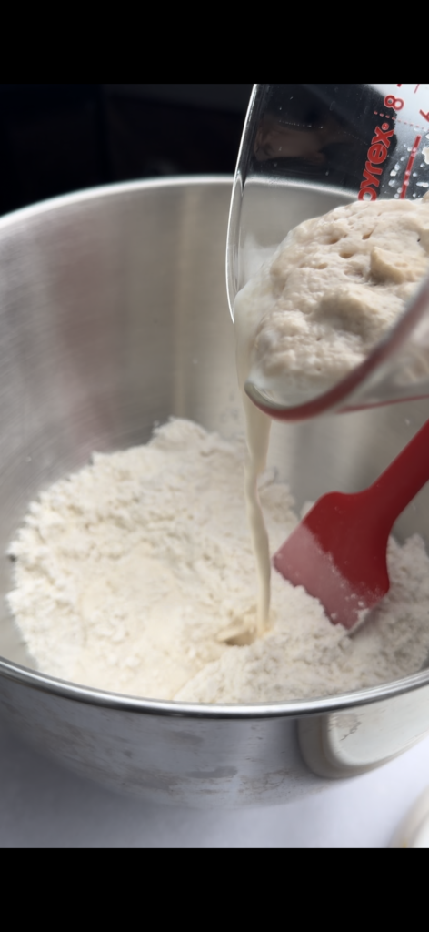 Yeast mixture being poured into dry ingredients.
