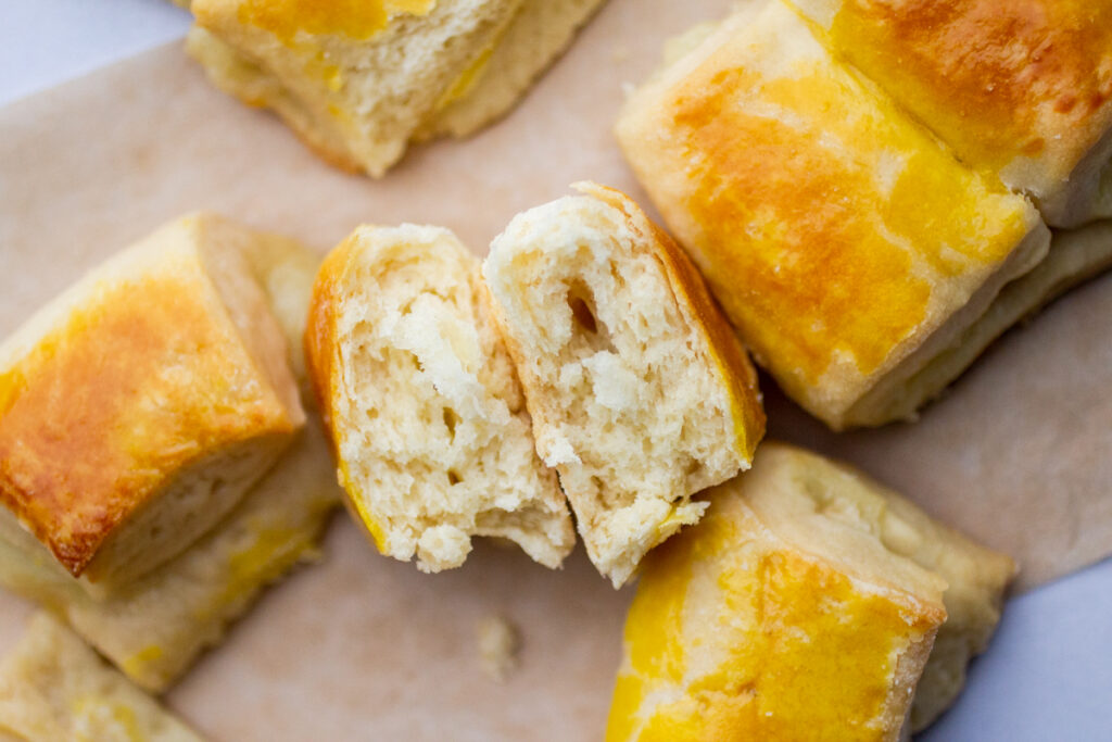 A cheese-stuffed roll broken in half to expose the cheesy middle.