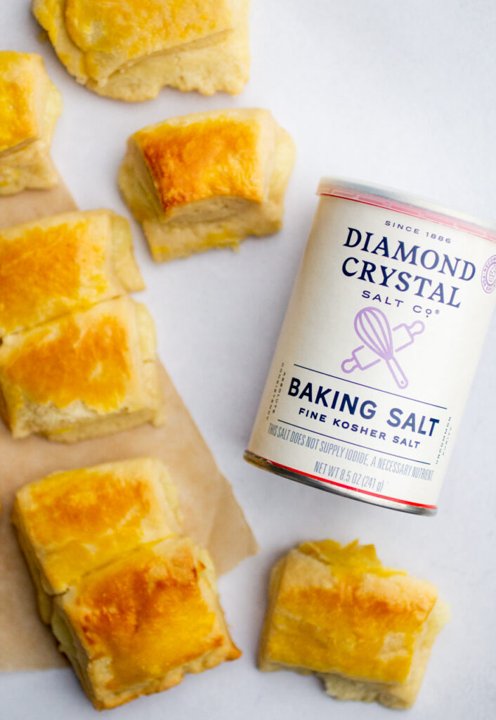 Cheese rolls on a gray background next to a container of Diamond Crystal baking salt.
