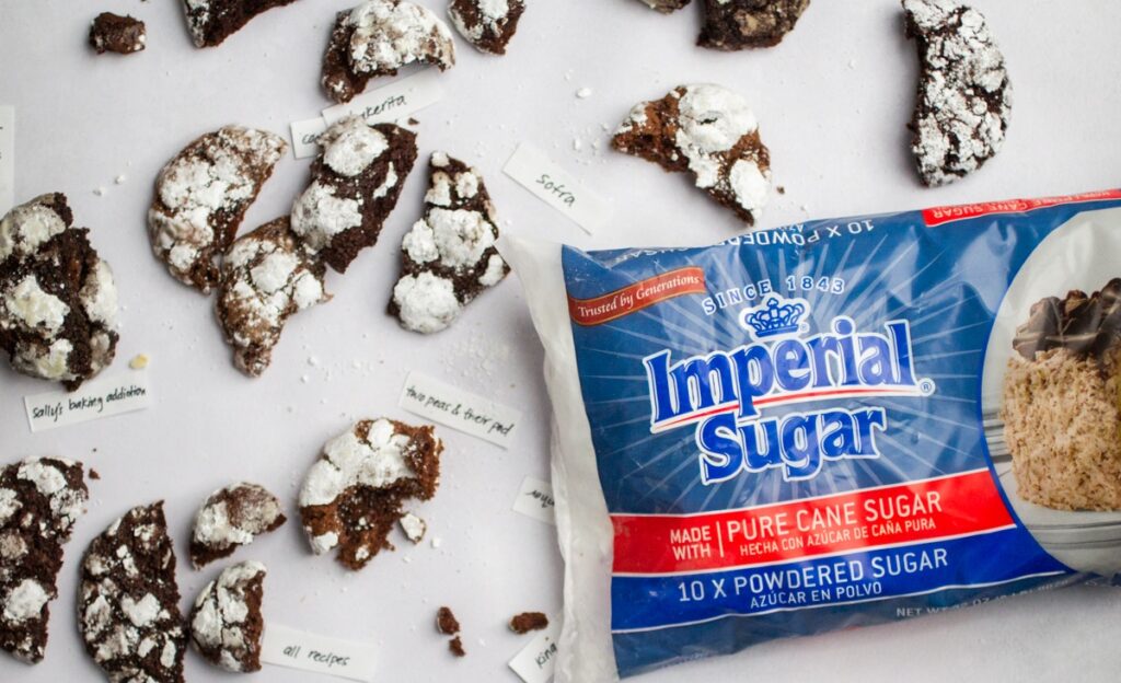 half-eaten chocolate crinkle cookies next to a bag of Imperial Sugar powdered sugar.