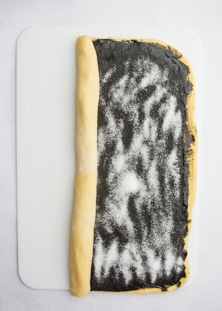 Assembled black sesame dough partially rolled up.