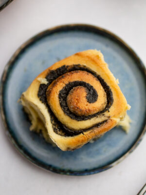 a black sesame sweet roll on a blue plate.
