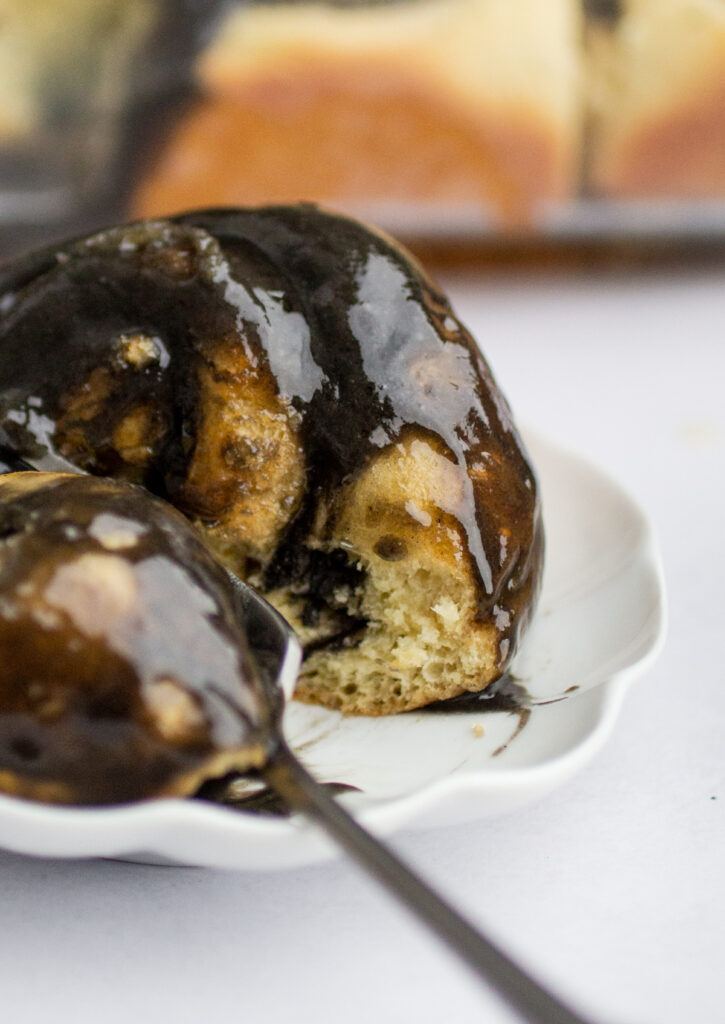 A close up of the interior of a black sesame sweet roll with a bite taken out of it.