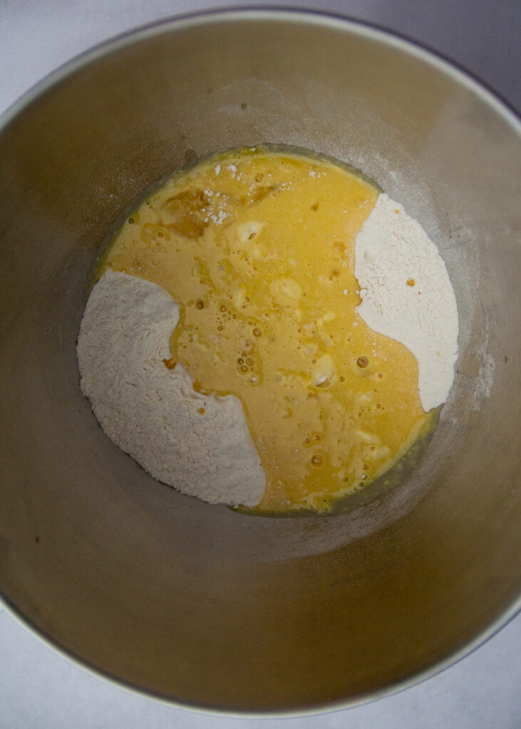 Wet ingredients added to dry ingredients in a bowl.