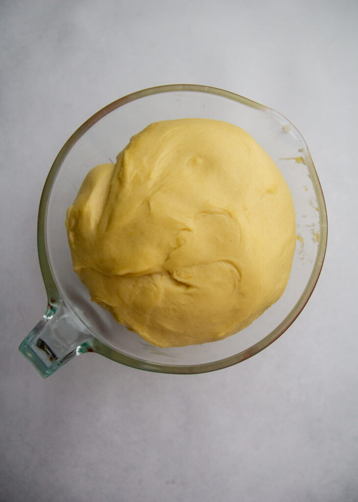 Risen dough in a measuring cup.