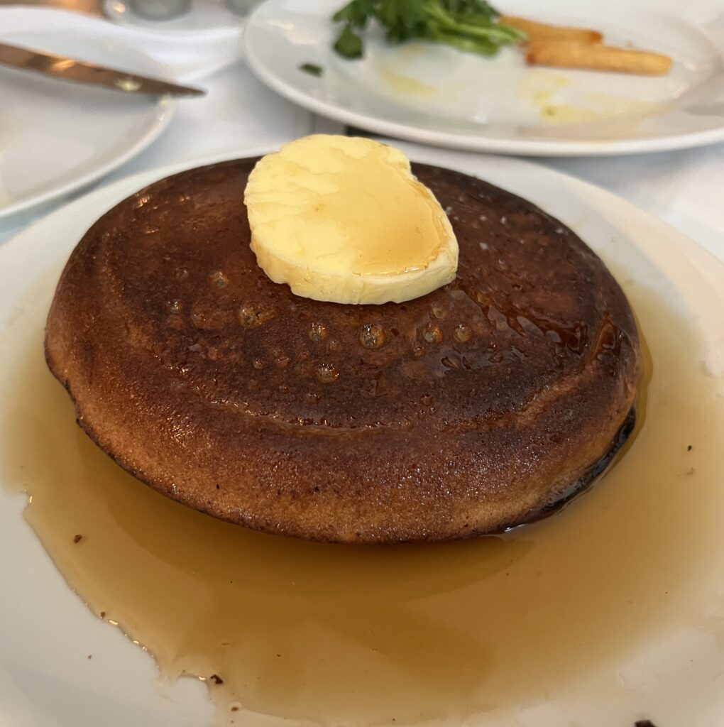A thick pancake topped with a round of butter from Frenchette.