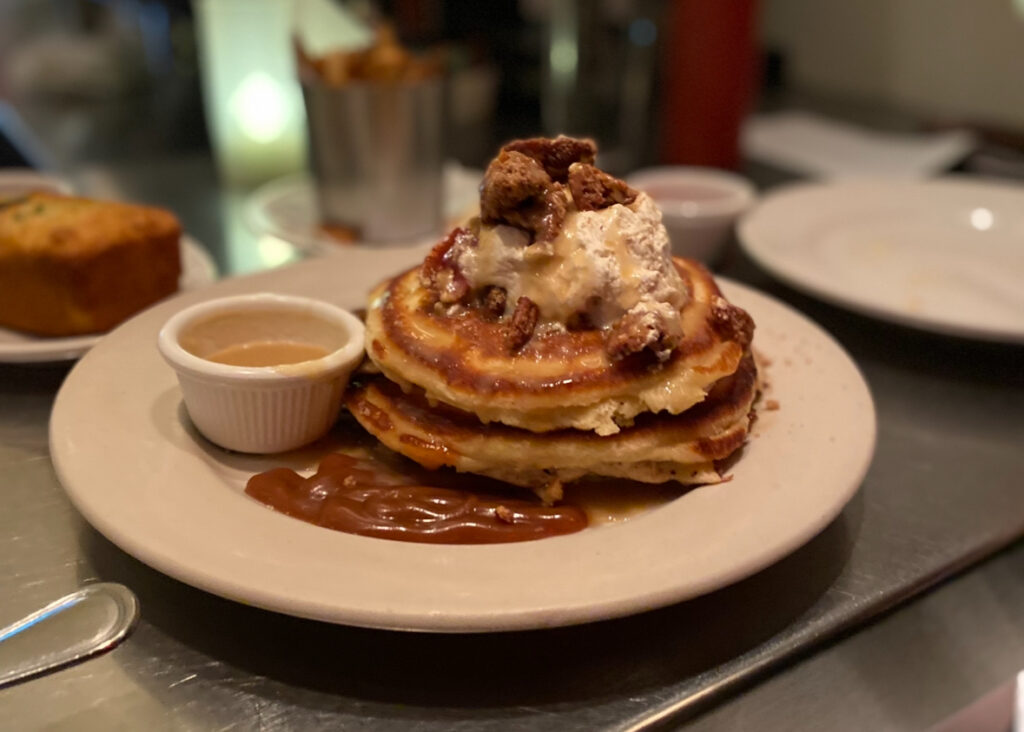 a stack of pancakes with syrup on a plate.