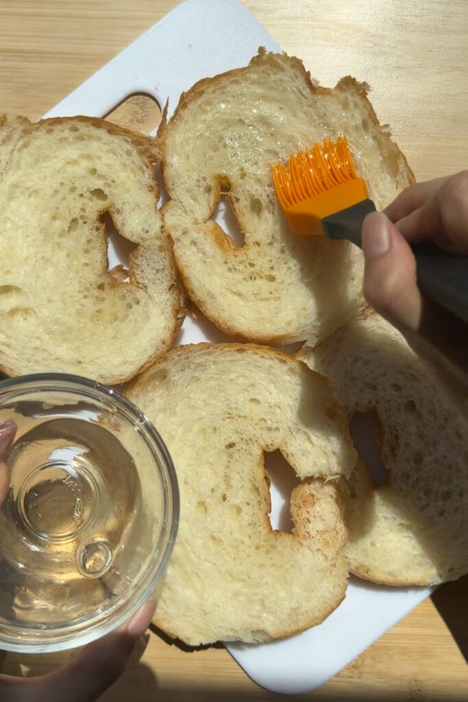 Brushing almond croissants with a simple syrup.