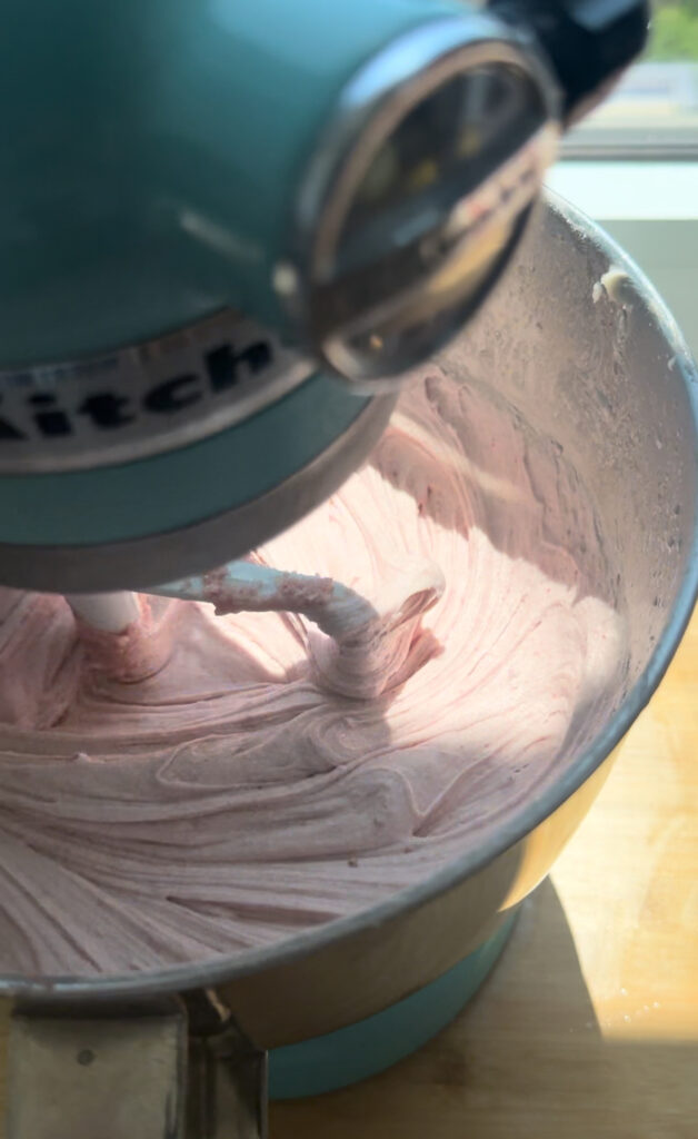 A mixing bowl with a silky mixture of strawberry cake batter.