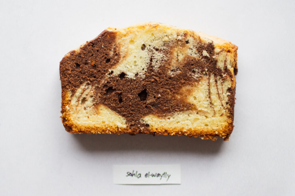 a slice of sohla el-waylly marble cake on a white background.