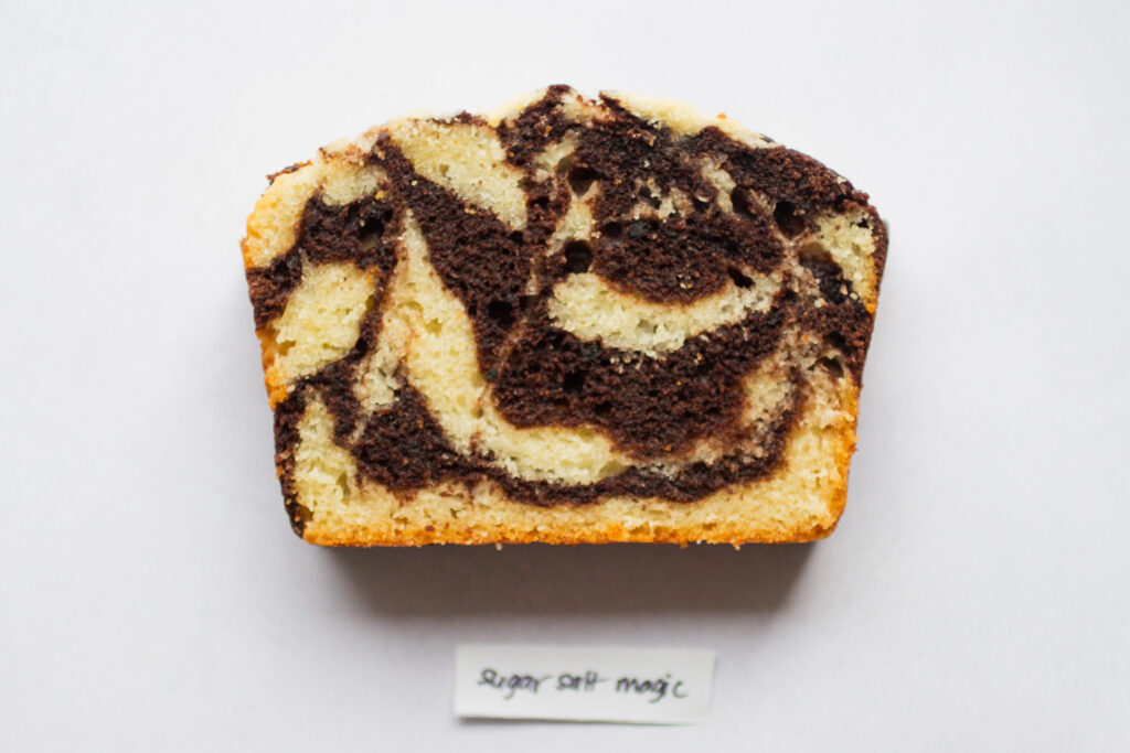 a slice of sugar salt magic marble cake on a white background.