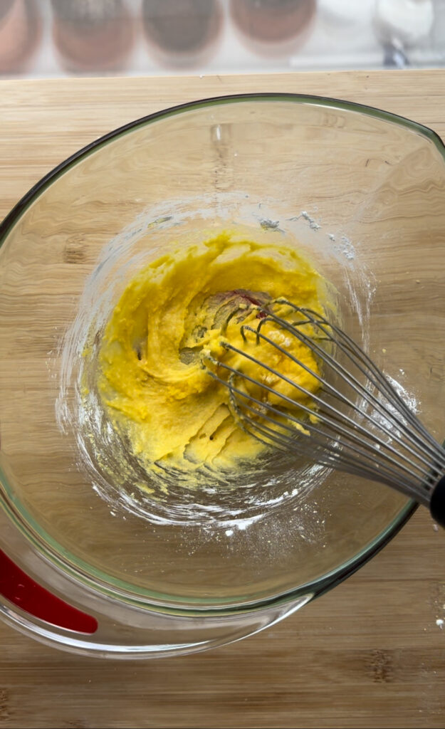 Egg yolks and sugar in a bowl.