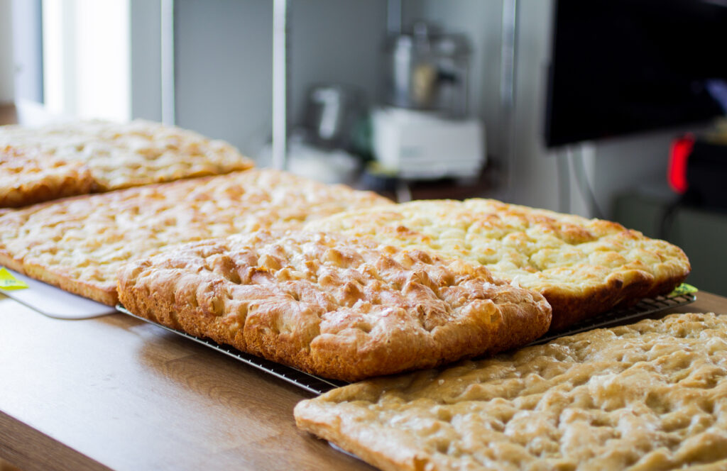 5 different types of focaccia on a counter.