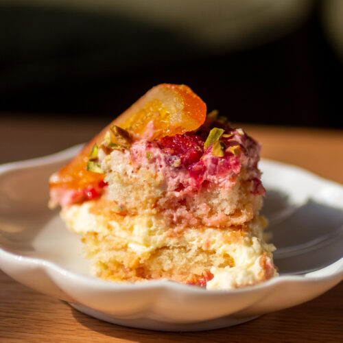 a slice of blood orange and raspberry tiramisu on a plate.
