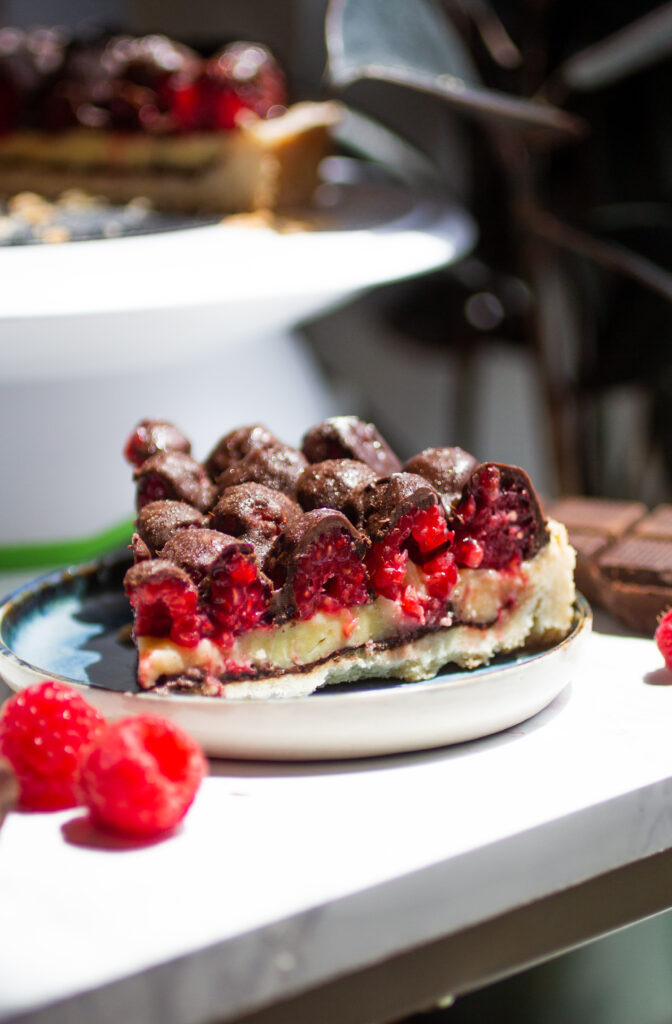 A slice of chocolate raspberry tart on a blue plate.