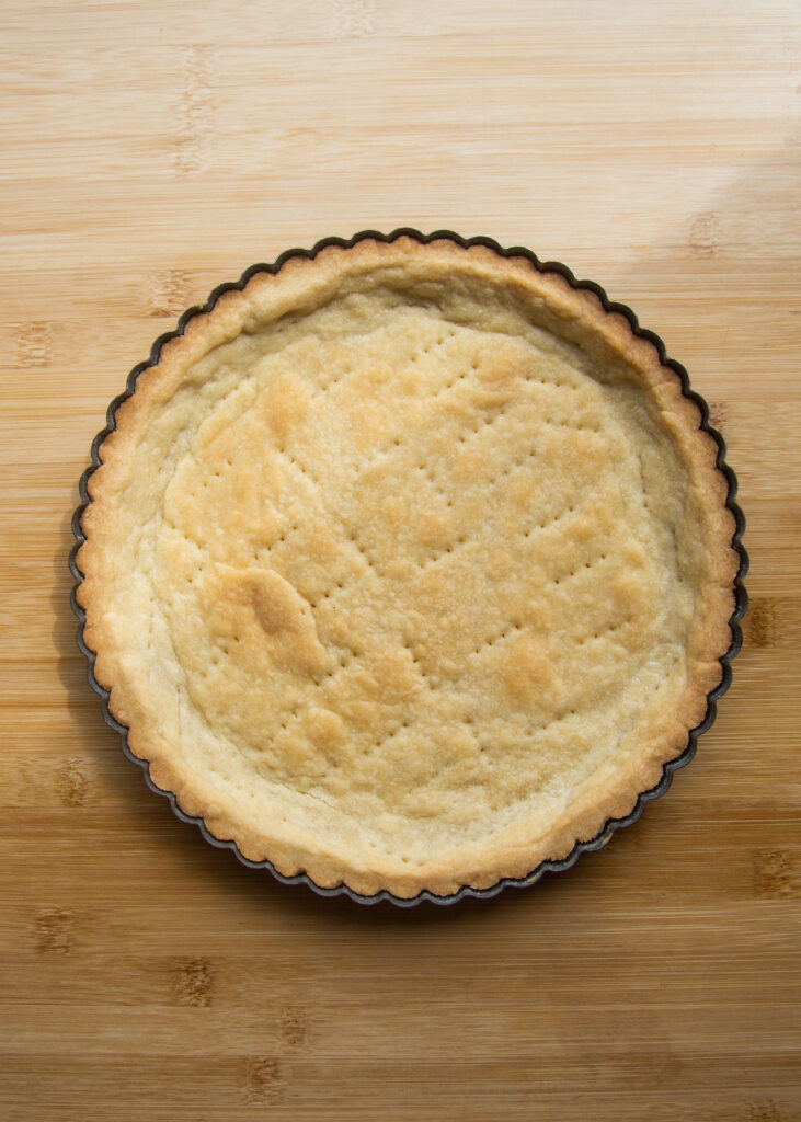 A baked tart shell with fork pin pricks.