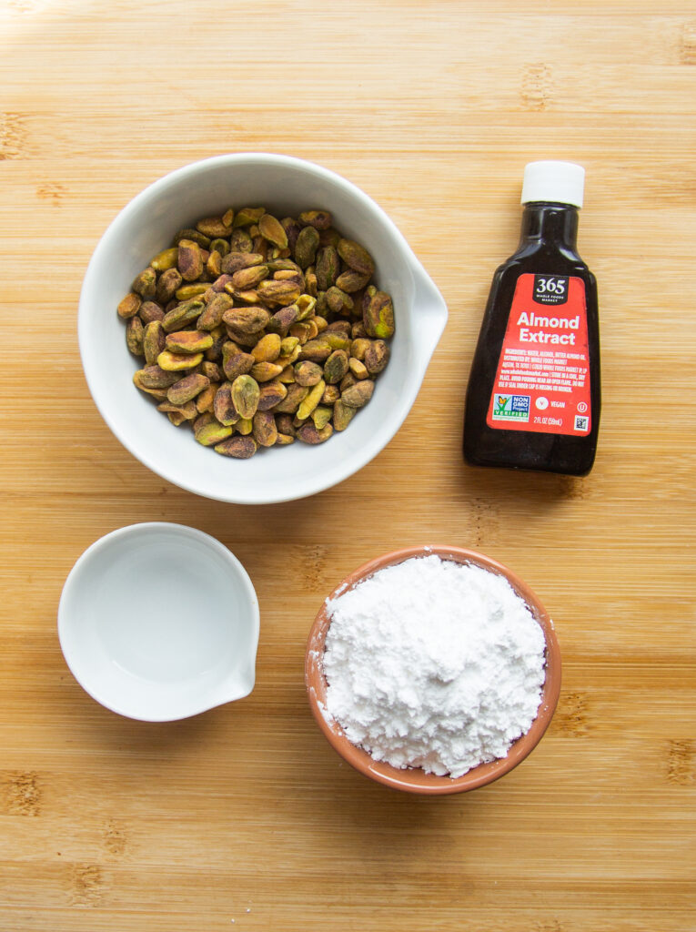 ingredients to make pistachio paste: whole pistachios, almond extract, powdered sugar and salt.