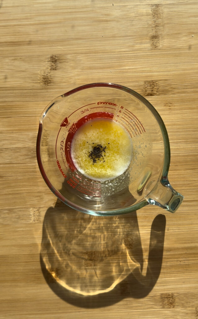 Melted butter and pepper in a measuring cup.