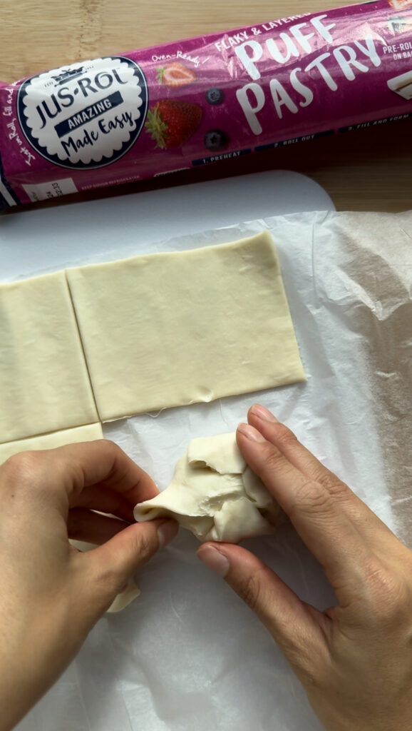 Wrapping the brie round and jam in puff pastry.