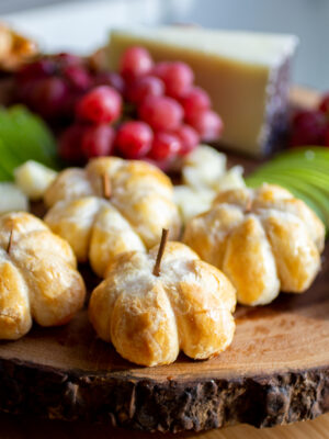 pumpkin-shaped brie bites on a cheeseboard.