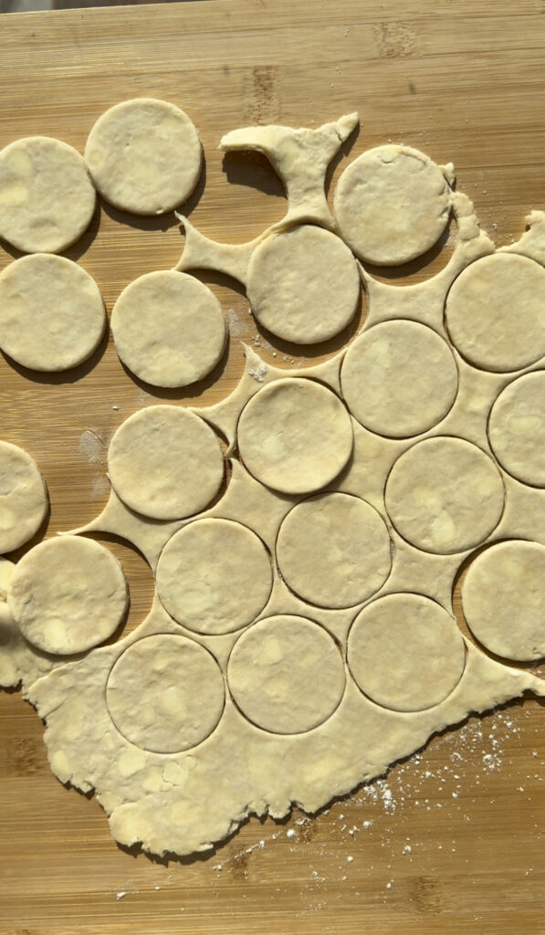 Cutting out circles from rolled out pie dough.