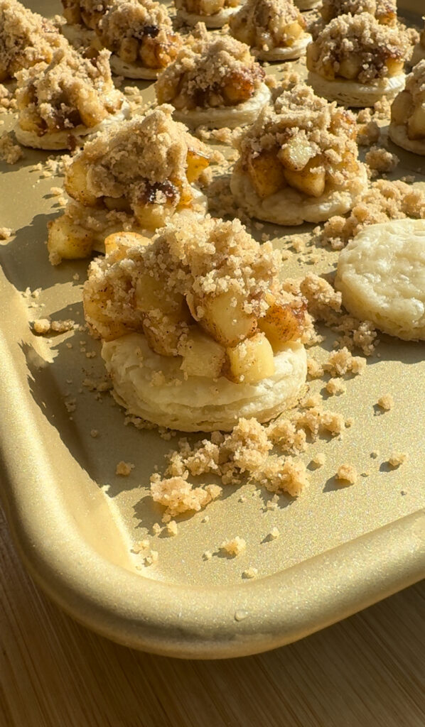 A round of pie crust topped with cooked apples and brown sugar crumbs.