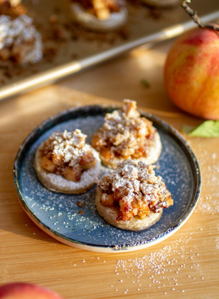 Three apple pie cookies on a blue plate.
