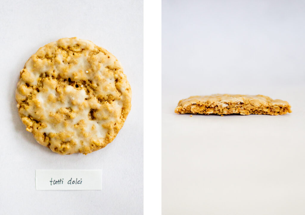 Tutti Dolci\'s iced oatmeal cookie on a gray background.