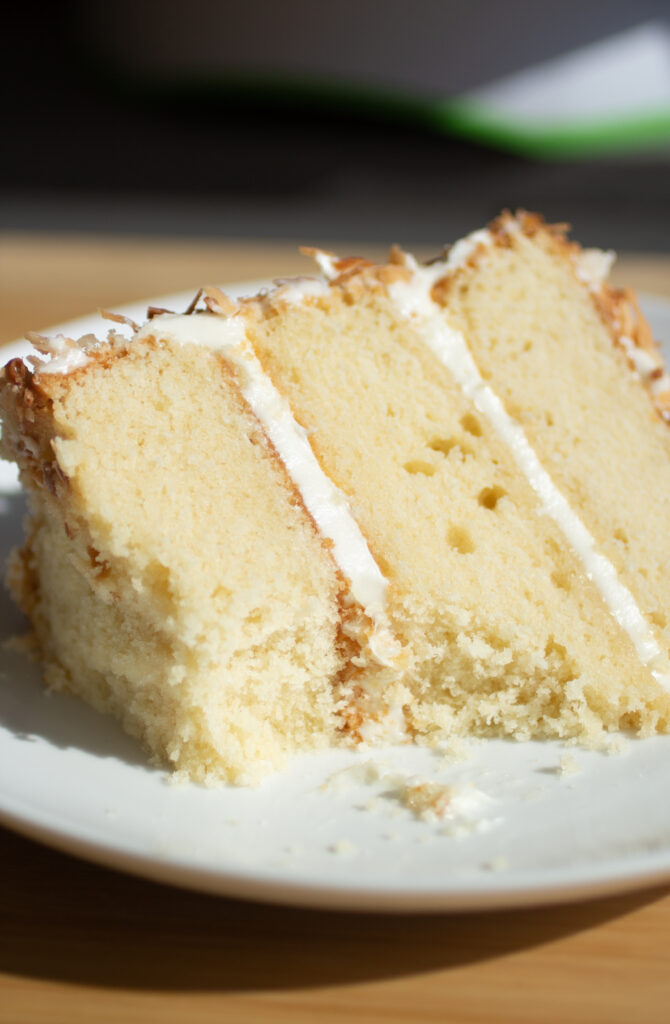 Close up on a bite taken out of a slice of cake to see the tight crumb.
