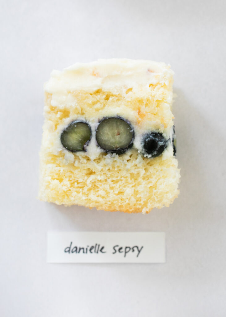 A slice of berry chantilly cake with the label "Danielle Sepsy."