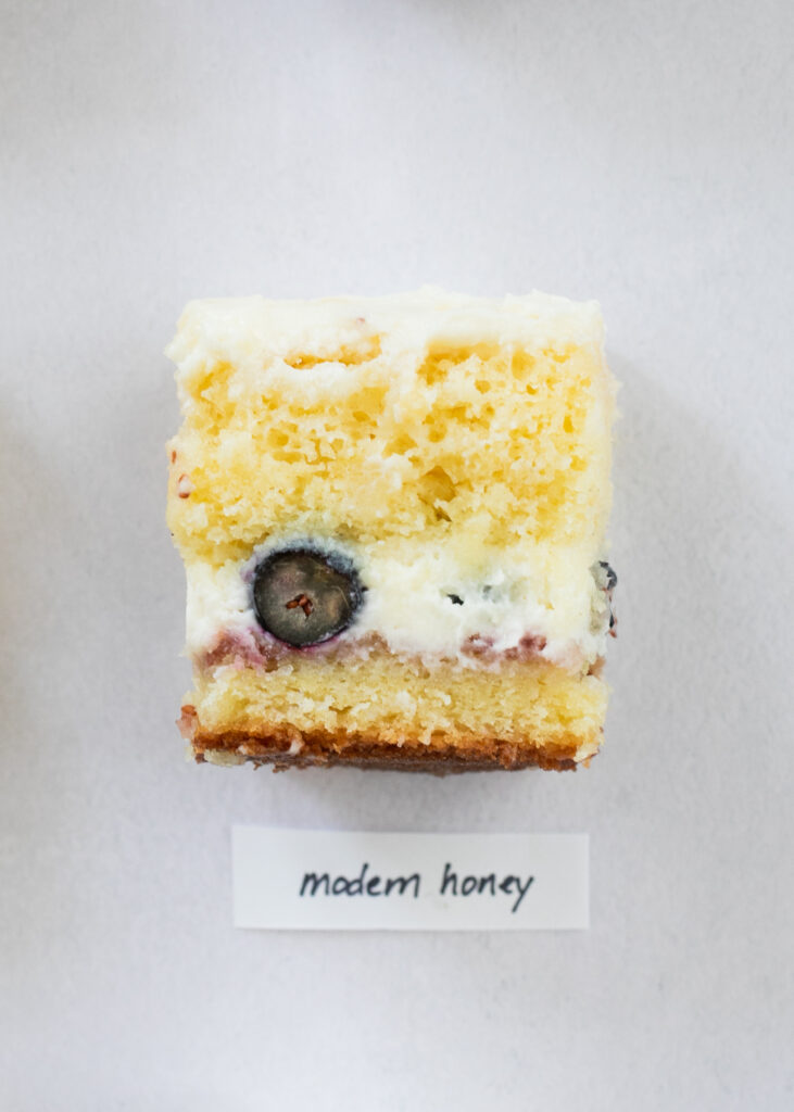 A slice of berry chantilly cake with the label "Modern Honey."