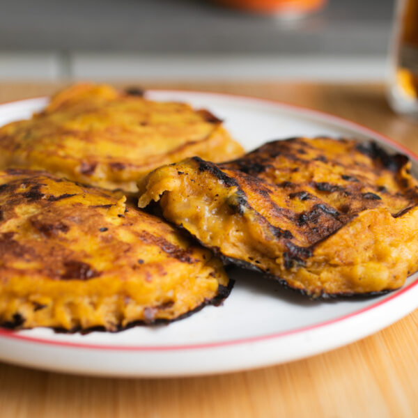 Three pumpkin panckes laid out on a white plate.