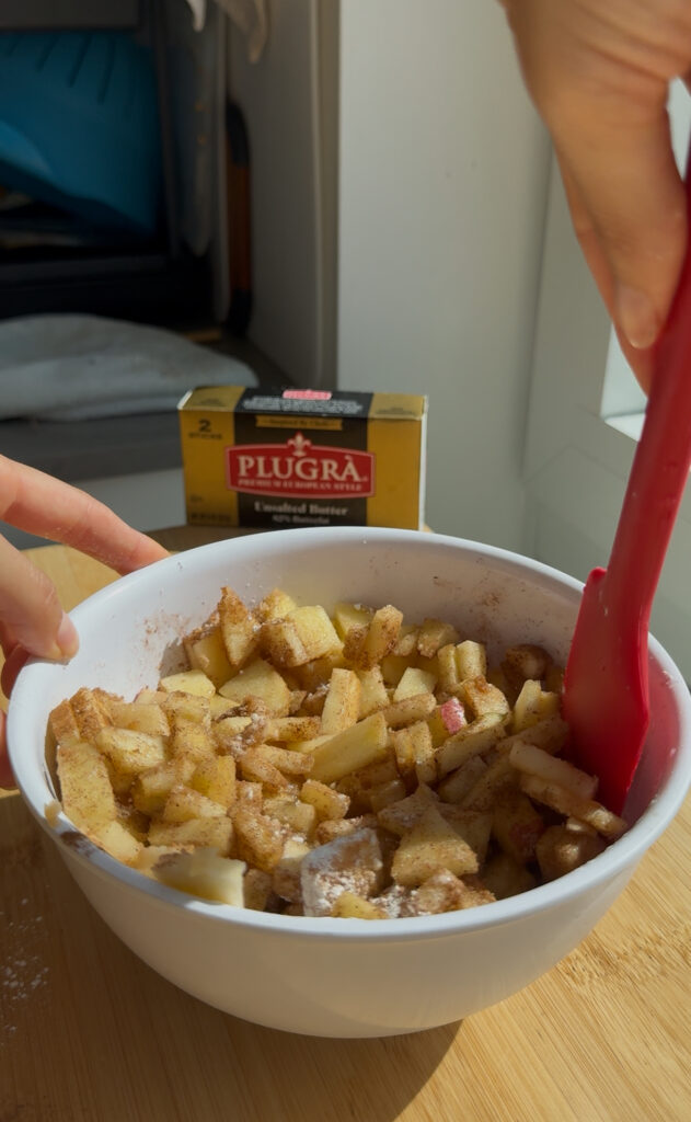 DIced apples, cinnamon and sugar mixed in a bowl.