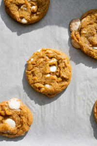 pumpkin white chocolate cookies on a baking sheet.