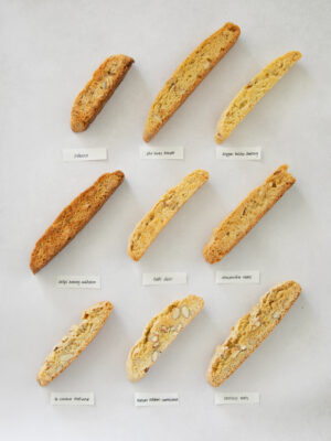 9 different almond biscotti on a gray background.