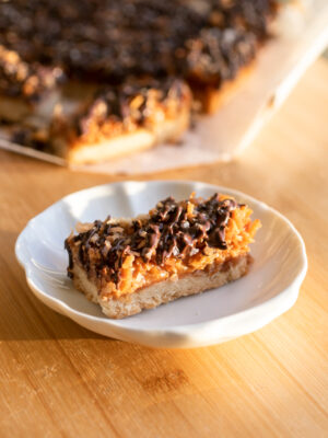 A coconut chocolate shortbread bar on a white plate.
