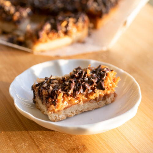 A coconut chocolate shortbread bar on a white plate.