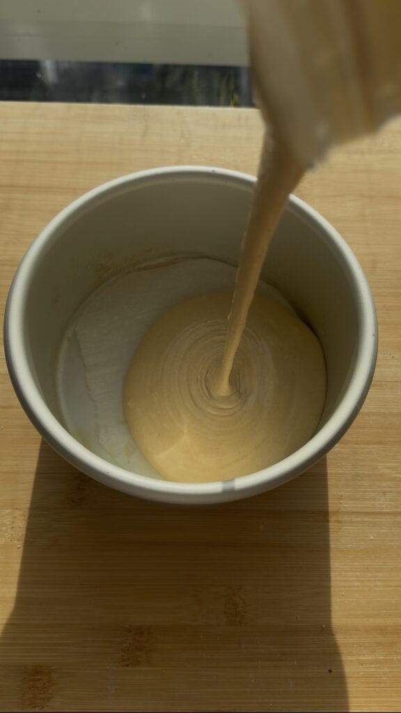Pouring batter into a round pan.