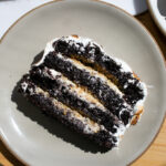 A slice of four layer chocolate s'mores cake on a plate.